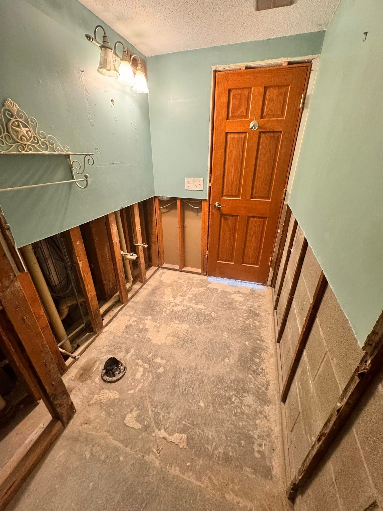 Bathroom before renovation — water damage with walls stripped to studs