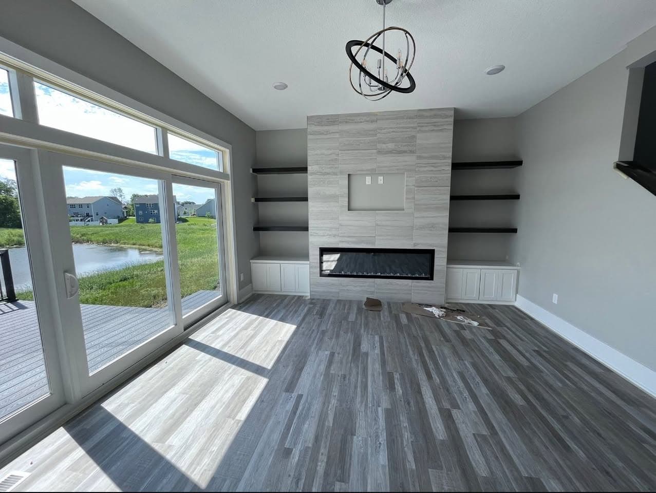 Modern living room fireplace remodel with custom tile surround and built-in shelves